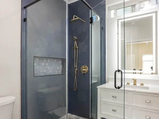 Bathroom with deep navy hexagonal tile and brass fixtures inside the Sherman Oaks ADU.