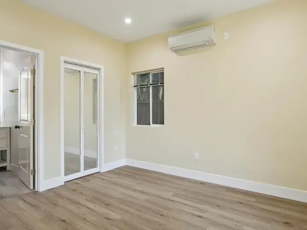 Bedroom inside the Sherman Oaks ADU with a closet and wall-mounted air conditioning.