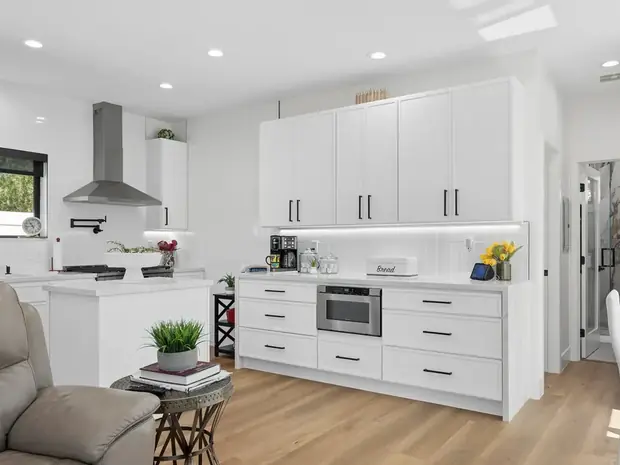 Full kitchen inside the Thousand Oaks ADU with white cabinetry and a range hood.