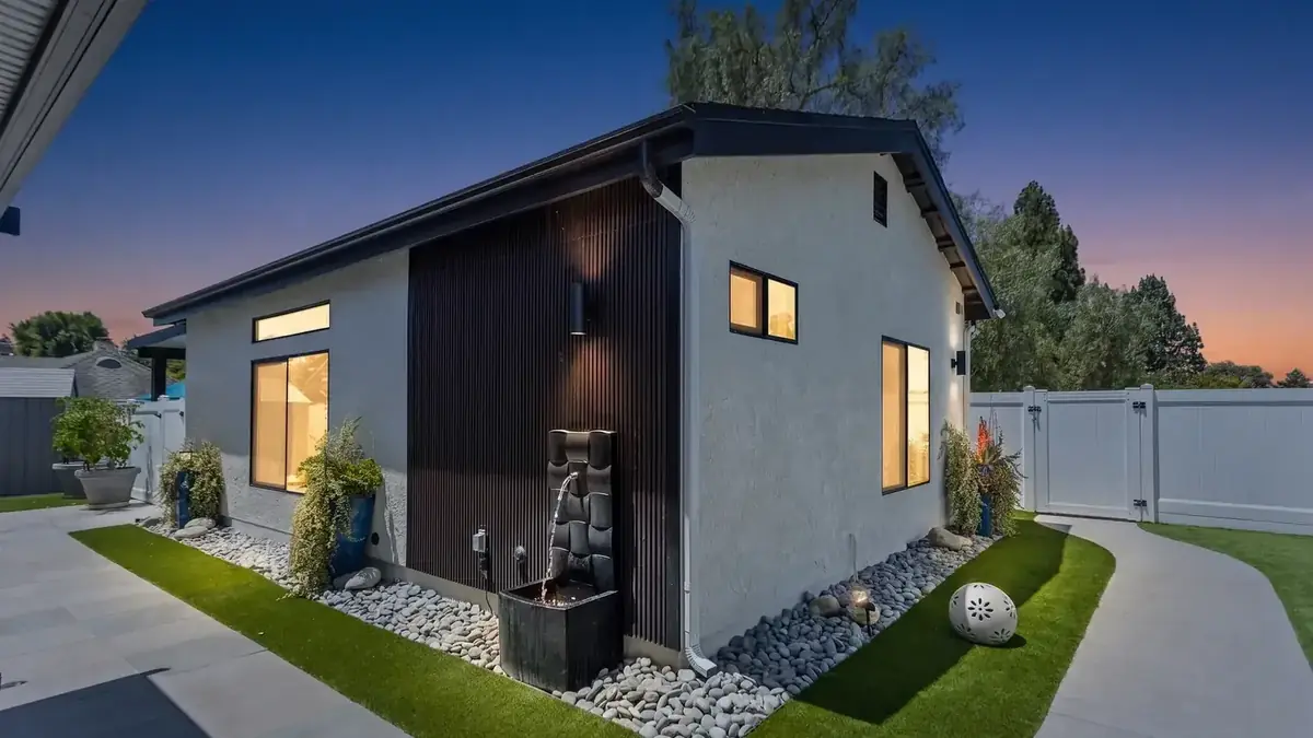 The completed detached ADU in Thousand Oaks photographed at dusk, showing the whole unit with lit windows and landscaped surrounds.
