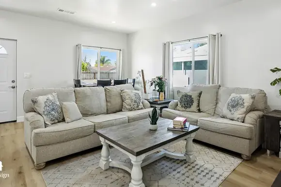 Furnished living room with sofa and vaulted ceiling inside a completed ADU.