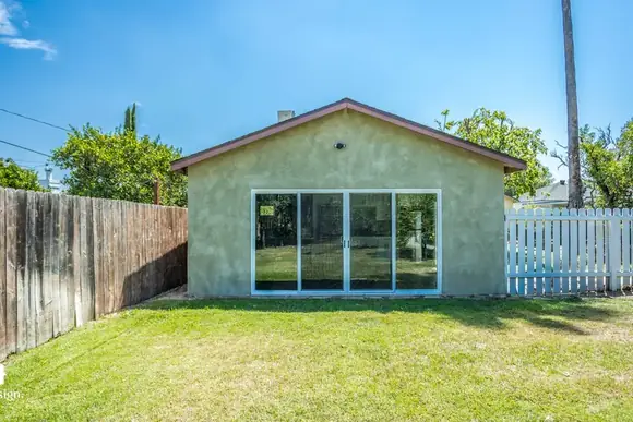 Exterior of a completed detached ADU with sliding glass doors onto a lawn.