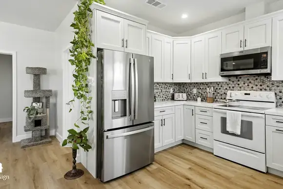 White ADU kitchen with patterned tile splashback and stainless appliances.