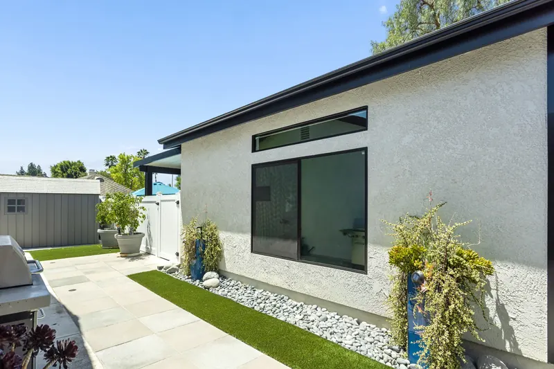 Exterior of a finished ADU with landscaping, stone borders and a private paved path.